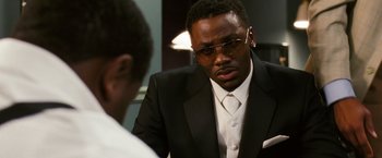 Movie still from “Notorious” (2009), directed by George Tillman Jr. – A man in a suit and tie talking to another man; Close Up shot, Over the shoulder angle