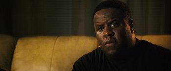 Movie still from “Notorious” (2009), directed by George Tillman Jr. – A person sitting on a couch; Close Up shot, Low angle