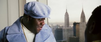 Movie still from “Notorious” (2009), directed by George Tillman Jr. – A man wearing a hat and a tie looking out of a window; Close Up shot, Low angle
