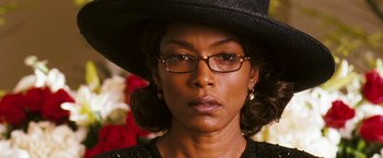 Movie still from “Notorious” (2009), directed by George Tillman Jr. – A person wearing glasses and a hat; Close Up shot, Over the shoulder angle