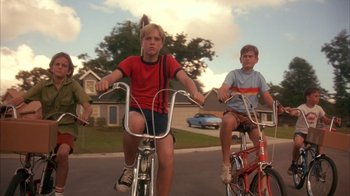 Movie still from “Now and Then” (1995), directed by Lesli Linka Glatter – A group of kids riding bikes down a street; Wide shot, Low angle