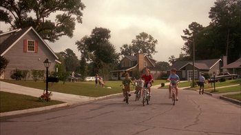 Movie still from “Now and Then” (1995), directed by Lesli Linka Glatter – A group of children riding bikes down a street; Extreme Wide shot, High angle