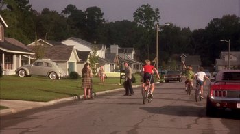 Movie still from “Now and Then” (1995), directed by Lesli Linka Glatter – A group of people riding bikes down a street; Wide shot, High angle