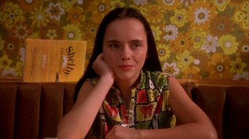 Movie still from “Now and Then” (1995), directed by Lesli Linka Glatter – A young woman sitting in front of a floral wall; Close Up shot, High angle