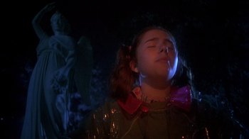 Movie still from “Now and Then” (1995), directed by Lesli Linka Glatter – A young girl with her eyes closed in the dark; Medium shot, Low angle