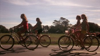 Movie still from “Now and Then” (1995), directed by Lesli Linka Glatter – A group of people riding bikes down a street; Wide shot, Low angle