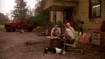 Movie still from “Now and Then” (1995), directed by Lesli Linka Glatter – A group of men playing a game of chess in a yard; Wide shot, High angle