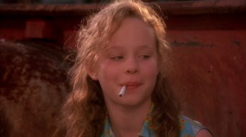 Movie still from “Now and Then” (1995), directed by Lesli Linka Glatter – A young girl is smoking a cigarette outside; Close Up shot, High angle