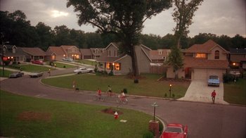 Movie still from “Now and Then” (1995), directed by Lesli Linka Glatter – A group of people riding bikes down a street; Extreme Wide shot, High angle