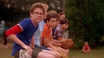 Movie still from “Now and Then” (1995), directed by Lesli Linka Glatter – A group of young men sitting on top of a bench; Medium shot, Low angle