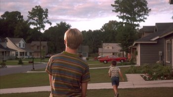 Movie still from “Now and Then” (1995), directed by Lesli Linka Glatter – Two young boys are running in the driveway; Wide shot, Low angle