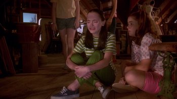Movie still from “Now and Then” (1995), directed by Lesli Linka Glatter – A girl sitting on the ground with her hands on her knees; Medium shot, High angle