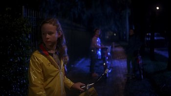 Movie still from “Now and Then” (1995), directed by Lesli Linka Glatter – A little girl in a yellow raincoat holding a bike; Medium shot, Over the shoulder angle