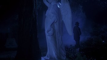 Movie still from “Now and Then” (1995), directed by Lesli Linka Glatter – A statue of an archangel in a dark forest; Wide shot, Low angle