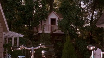 Movie still from “Now and Then” (1995), directed by Lesli Linka Glatter – A bicycle parked in front of a tree with a tree house in the background; Extreme Wide shot, Low angle