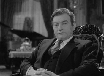 Movie still from “Now, Voyager” (1942), directed by Irving Rapper – Black and white photograph of a man in a suit and tie; Close Up shot, Over the shoulder angle