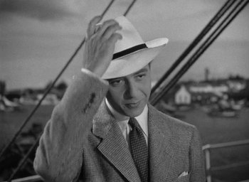 Movie still from “Now, Voyager” (1942), directed by Irving Rapper – A black and white photo of a man wearing a hat; Close Up shot, High angle