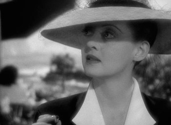 Movie still from “Now, Voyager” (1942), directed by Irving Rapper – A black and white photo of a woman wearing a hat; Close Up shot, Low angle