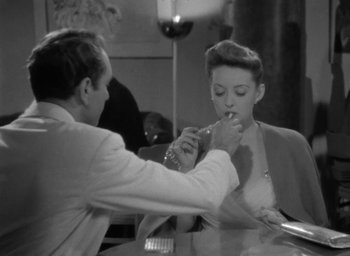 Movie still from “Now, Voyager” (1942), directed by Irving Rapper – A man and a woman are eating together; Medium shot, High angle