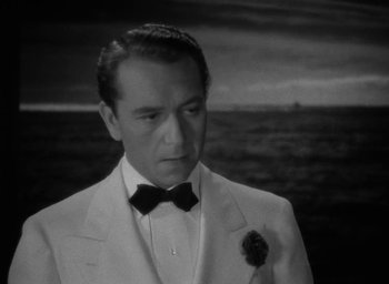 Movie still from “Now, Voyager” (1942), directed by Irving Rapper – A man wearing a suit and a bow tie; Close Up shot, High angle