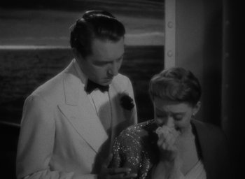 Movie still from “Now, Voyager” (1942), directed by Irving Rapper – A man and a woman looking at a cell phone; Medium shot, High angle