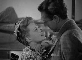 Movie still from “Now, Voyager” (1942), directed by Irving Rapper – A man and a woman kissing each other in a black and white photo; Close Up shot, High angle