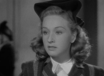 Movie still from “Now, Voyager” (1942), directed by Irving Rapper – A black and white photo of a woman with a hat; Close Up shot, Over the shoulder angle