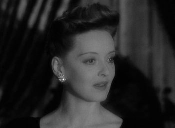 Movie still from “Now, Voyager” (1942), directed by Irving Rapper – A black - and - white photo of a woman in a black dress; Close Up shot, High angle