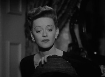 Movie still from “Now, Voyager” (1942), directed by Irving Rapper – An old black and white photo of a woman looking down; Close Up shot, High angle