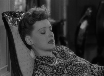 Movie still from “Now, Voyager” (1942), directed by Irving Rapper – An old black and white photo of a woman laying on a chair; Close Up shot, Overhead angle