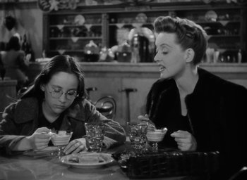 Movie still from “Now, Voyager” (1942), directed by Irving Rapper – A couple of women sitting at a table eating food; Medium shot, High angle