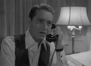 Movie still from “Now, Voyager” (1942), directed by Irving Rapper – A black and white photo of a man talking on a phone; Close Up shot, High angle