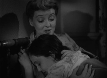 Movie still from “Now, Voyager” (1942), directed by Irving Rapper – A woman is holding a child while sitting on a couch; Medium shot, High angle