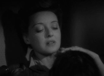 Movie still from “Now, Voyager” (1942), directed by Irving Rapper – A black - and - white photo of a woman with her eyes closed; Close Up shot, High angle