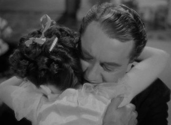 Movie still from “Now, Voyager” (1942), directed by Irving Rapper – A man and a little girl hugging each other; Close Up shot, High angle