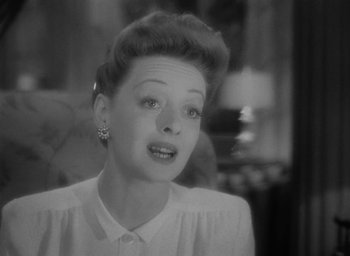 Movie still from “Now, Voyager” (1942), directed by Irving Rapper – A black - and - white photo of a woman in a white shirt; Close Up shot, Low angle