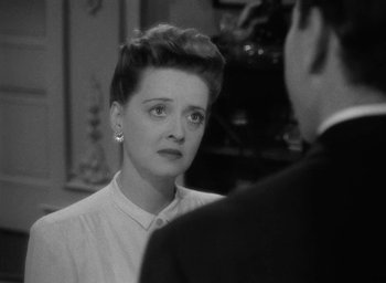 Movie still from “Now, Voyager” (1942), directed by Irving Rapper – An old black and white photo of a woman looking at a man; Close Up shot, High angle