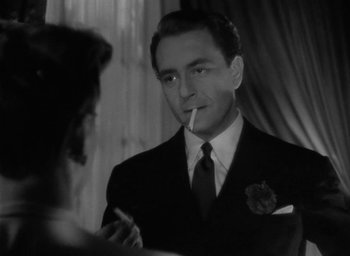 Movie still from “Now, Voyager” (1942), directed by Irving Rapper – A black and white photo of a man smoking a cigarette; Close Up shot, Over the shoulder angle