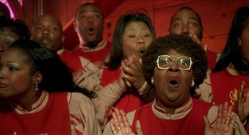 Movie still from “Nutty Professor II: The Klumps” (2000), directed by Peter Segal – A group of people that are standing up in a room; Close Up shot, Low angle