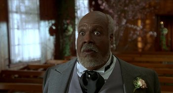 Movie still from “Nutty Professor II: The Klumps” (2000), directed by Peter Segal – An older man wearing a suit and tie; Close Up shot, Low angle