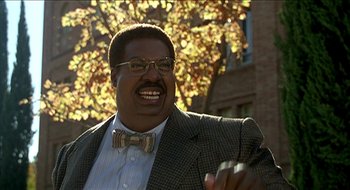 Movie still from “Nutty Professor II: The Klumps” (2000), directed by Peter Segal – A person wearing glasses and a bow tie; Medium shot, Low angle