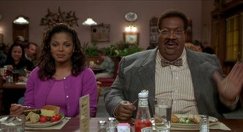 Movie still from “Nutty Professor II: The Klumps” (2000), directed by Peter Segal – Two people sitting at a table in a restaurant; Medium shot, Low angle
