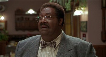 Movie still from “Nutty Professor II: The Klumps” (2000), directed by Peter Segal – A person wearing glasses and a bow tie; Close Up shot, Low angle