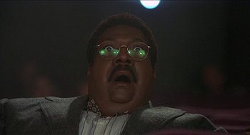 Movie still from “Nutty Professor II: The Klumps” (2000), directed by Peter Segal – A person wearing glasses and a suit; Close Up shot, Low angle
