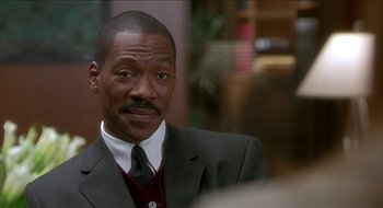 Movie still from “Nutty Professor II: The Klumps” (2000), directed by Peter Segal – A person wearing a suit and tie; Close Up shot, Over the shoulder angle