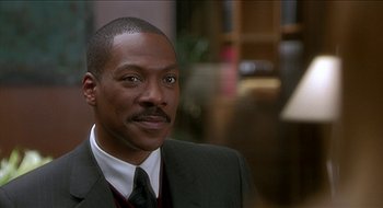Movie still from “Nutty Professor II: The Klumps” (2000), directed by Peter Segal – A person wearing a suit and tie; Close Up shot, Over the shoulder angle