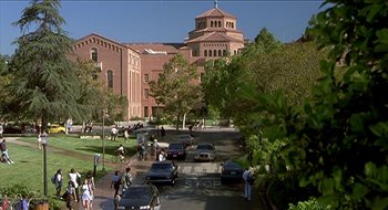 Movie still from “Nutty Professor II: The Klumps” (2000), directed by Peter Segal – Cars parked on the side of the street near a building; Extreme Wide shot, High angle