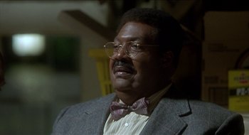 Movie still from “Nutty Professor II: The Klumps” (2000), directed by Peter Segal – A person wearing glasses and a bow tie; Close Up shot, Low angle