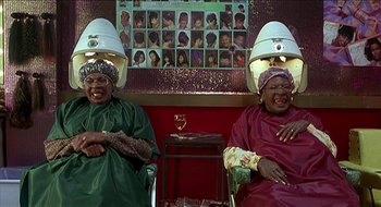 Movie still from “Nutty Professor II: The Klumps” (2000), directed by Peter Segal – A couple of people that are sitting in a room; Medium shot, High angle
