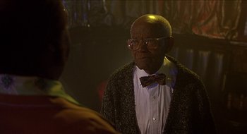 Movie still from “Nutty Professor II: The Klumps” (2000), directed by Peter Segal – An older man wearing a bow tie and glasses; Close Up shot, Over the shoulder angle